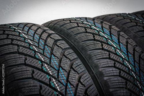 Winter car tires in row isolated on gray