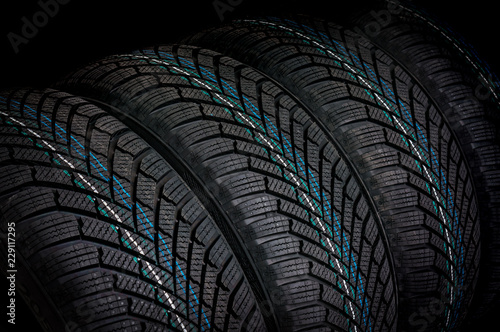 Winter car tires in row isolated on black