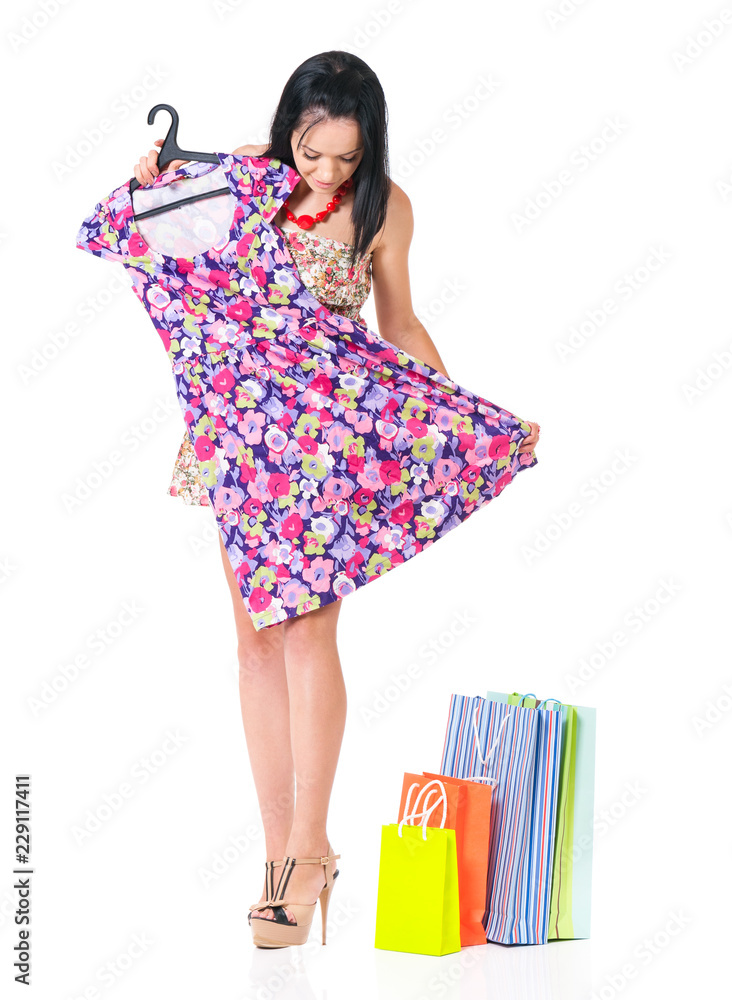 Beautiful young woman with new colourful dress and shopping bags, isolated on white background Beautiful young woman with new colourful dress and shopping bags, isolated on white background