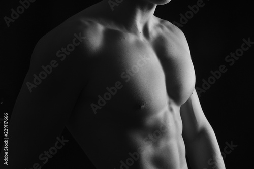 naked breast of a man on black background