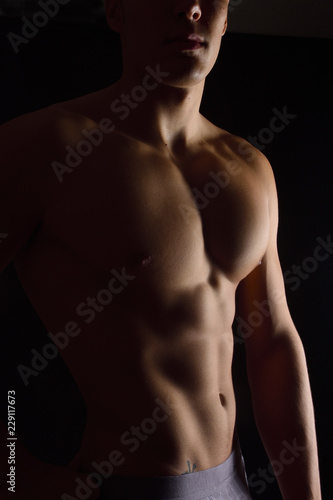naked body of a man on black background