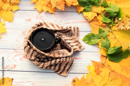 Autumn leaves, Tea cup, dark transparent, Scarf against gray wooden background. © sir270