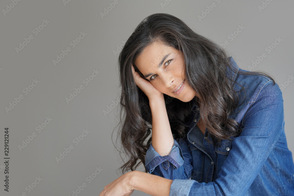 Brunette woman standing on grey background, isolated Brunette woman standing on grey background, isolated