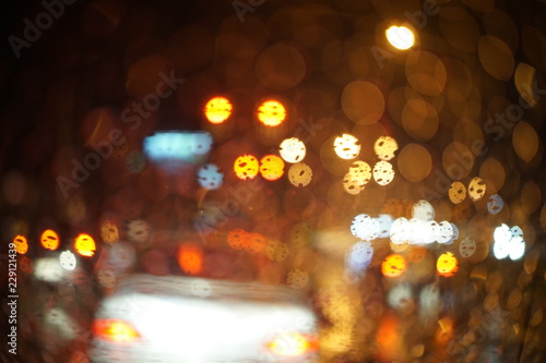 Rainy night traffic light - selective focus on the raindrop abstract bokeh of light