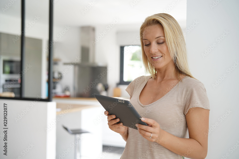 Middle-aged woman at home connected with digital tablet Middle-aged woman at home connected with digital tablet