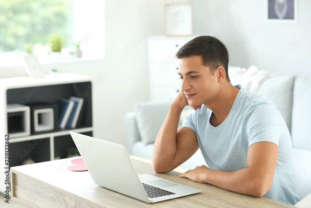 Young man having online dating at home