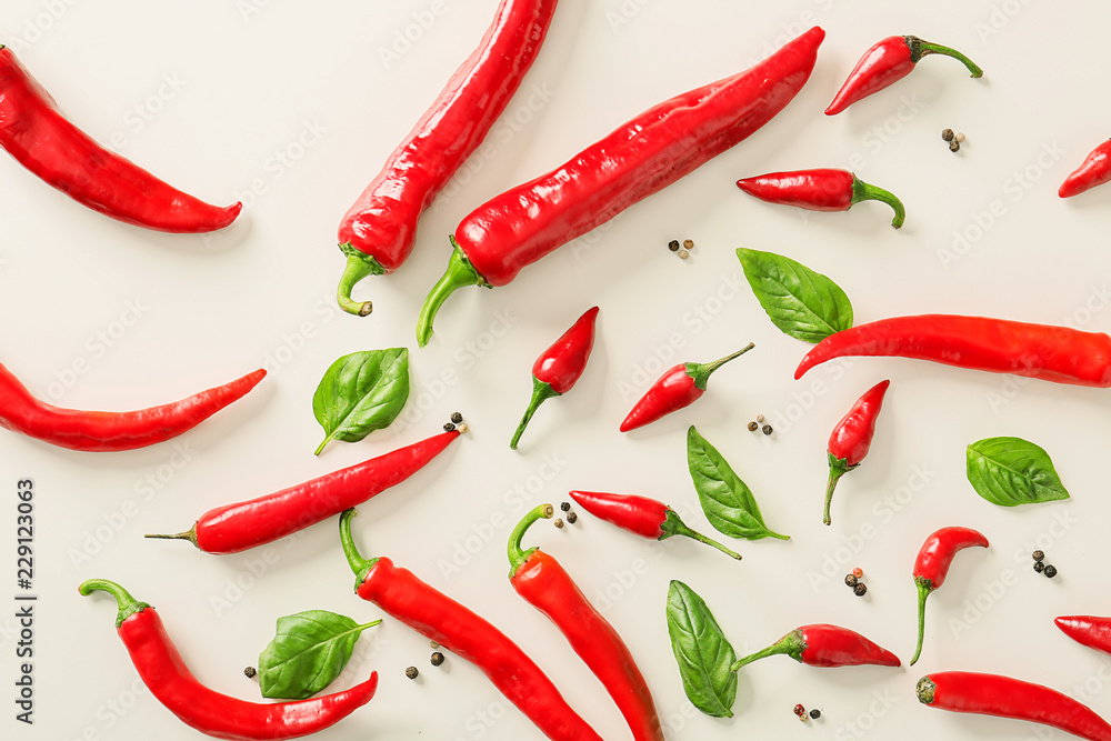 Flat lay composition with fresh chili peppers, spices and basil on light background Flat lay composition with fresh chili peppers, spices and basil on light background