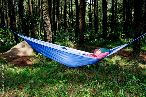 Happy asian traveler woman relaxing in hammock