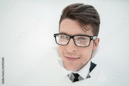 young businessman breaking through a paper wall