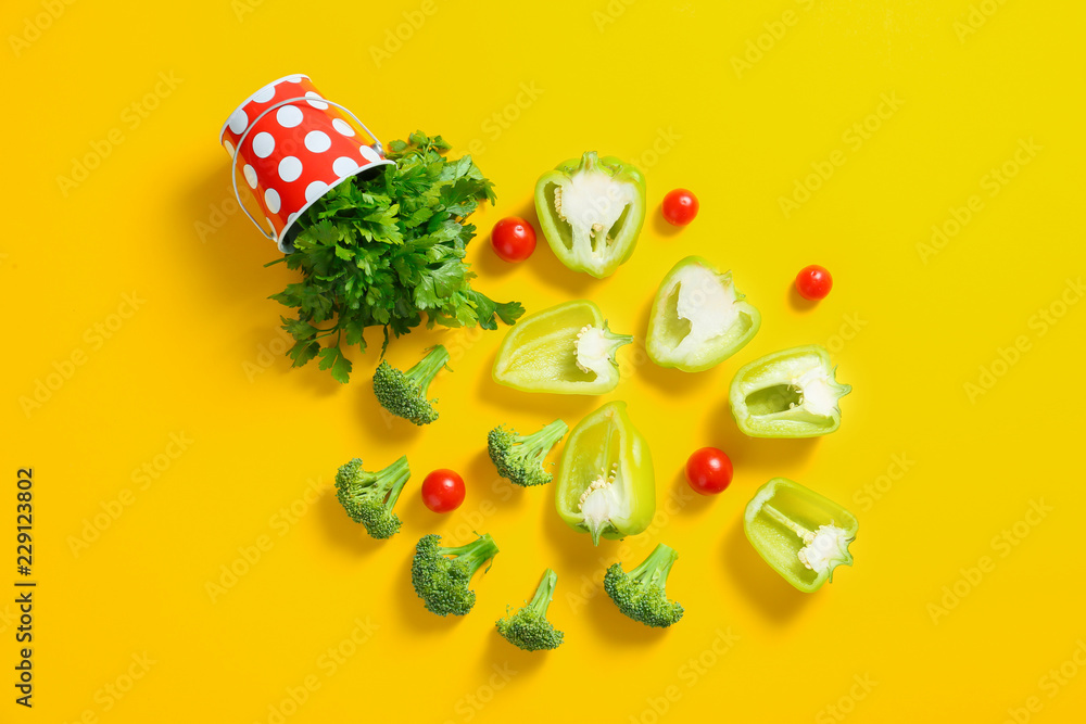 Flat lay composition with various vegetables and metal bucket on color background