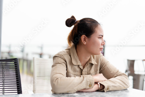 woman sitting at a table  in a cafe. Waiting, hope, daytime.
