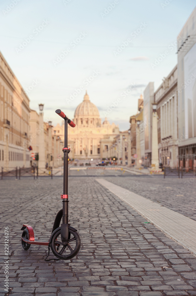 Red push scooters against the backdrop of the Vatican in the Roma, Italy. Vertical.