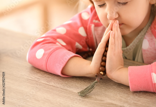 Little girl with beads pray...