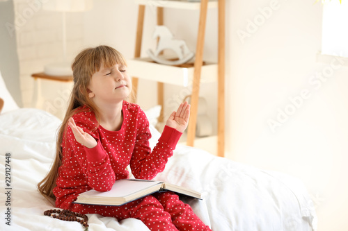 Little girl with Bible pray...