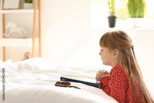 Little girl with Bible pray...