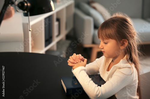 Little girl with Bible pray...