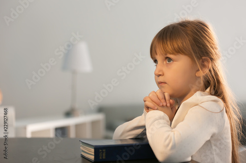 Little girl with Bible pray...