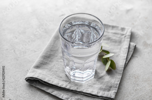 Glass of cold water on grey table
