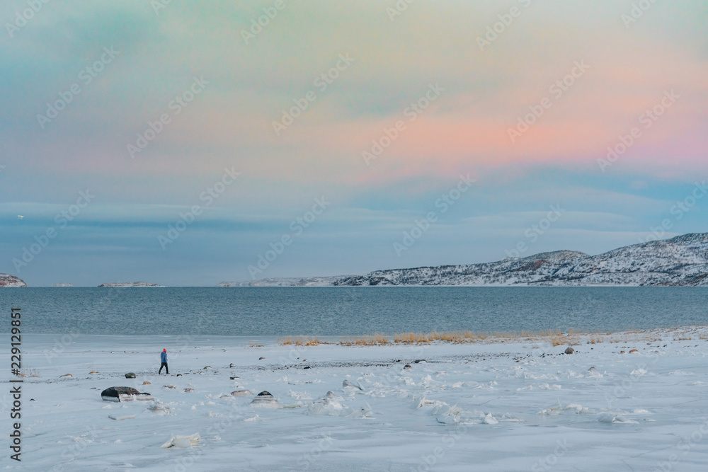 One man walking on a snowy valley far in the north One man walking on a snowy valley far in the north