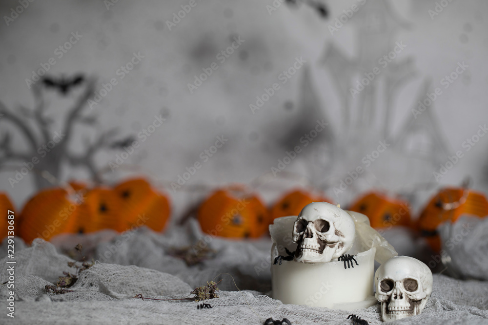 Skull on an old used thick candle. Scary Halloween background.