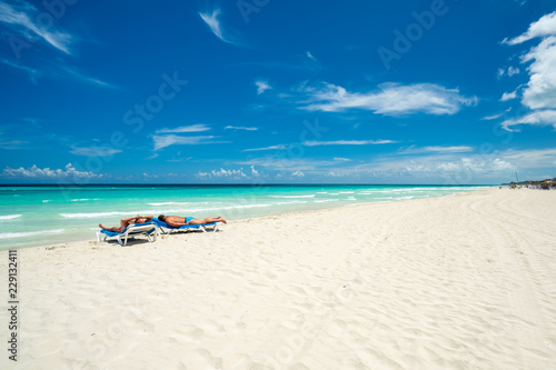 Beautiful beach of Varadero during the day,two tourists lying on sea beds tan,Varadero Cuba. © robertobinetti70
