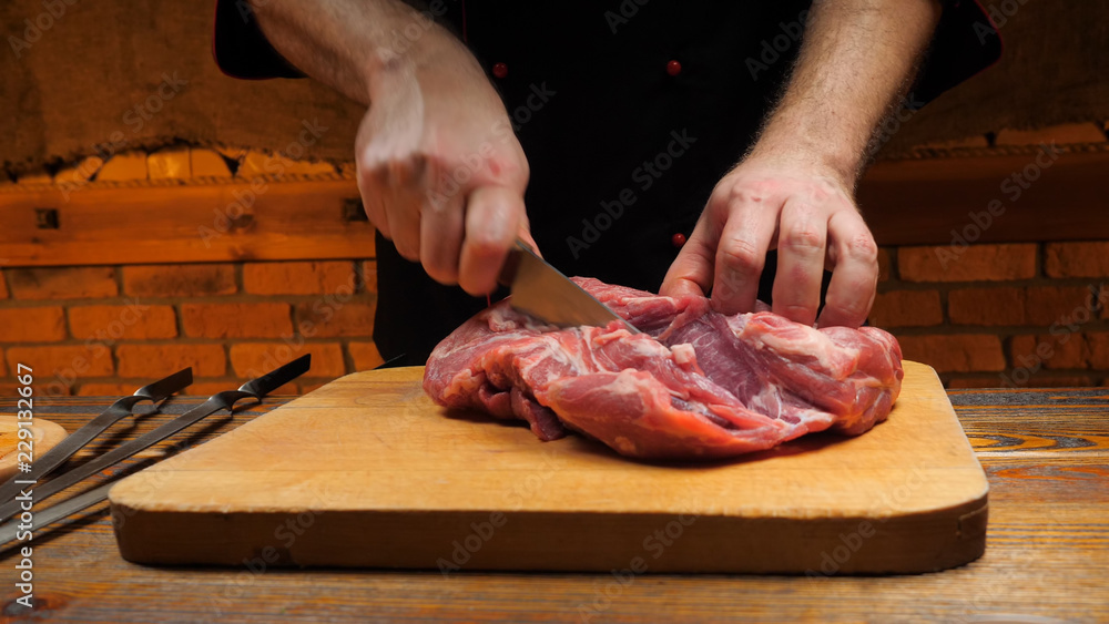 Man  is cutting pork on a cutting board