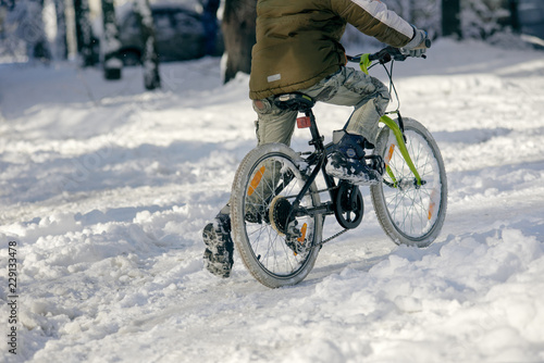 Closeup photo of guy riding bicycle on snowy background © Denys Kurbatov