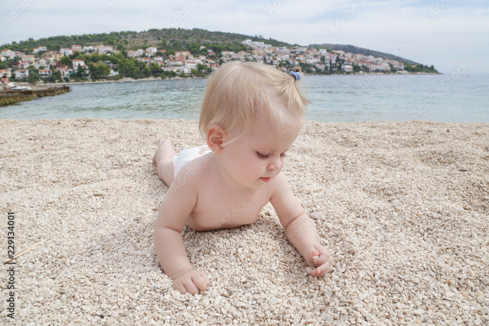 Adorable cheerful baby crawling on the pebble beach
Adorable cheerful baby crawling on the pebble beach