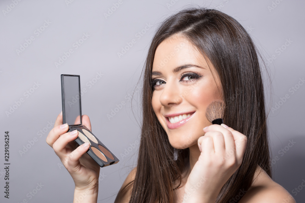sexy girl applying blush on her chic bones .beauty make up sexy girl applying blush on her chic bones .beauty make up