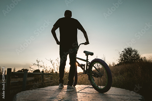 Young man with a bmx bicycle. Guy standing with his bmx.