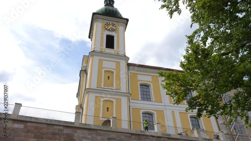 Camera tilts down from the St. Johann Church to the statue 