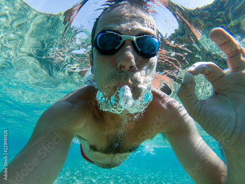 Underwater view of swimming man in the sea