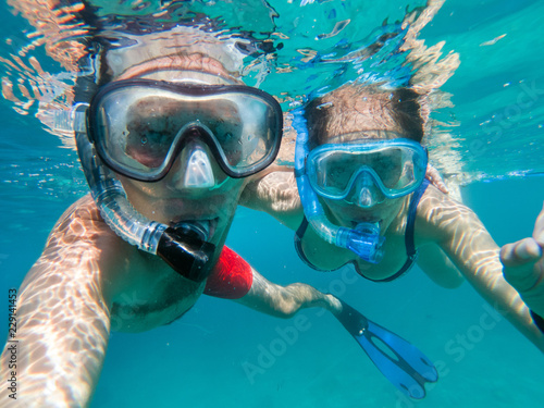 Snorkeling couple in love taking selfie underwater