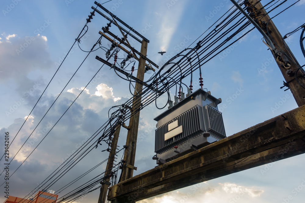 Electrical transformer, High voltage power transformer in town with sky on evening background
