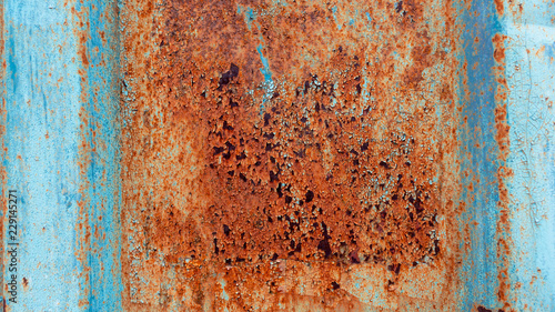 Rusty metal background with old layers of blue paint. Texture rusted shipping container.