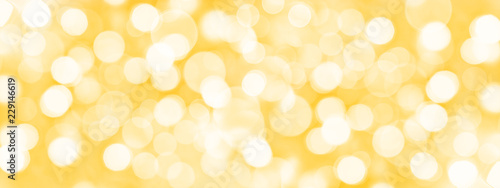 Holiday golden panoramic background with blurred bokeh lights