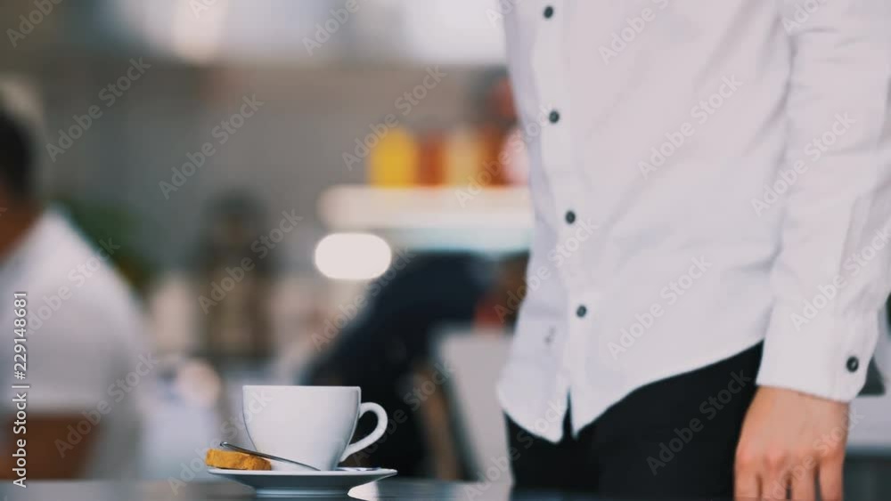 Man wearing white shirt putting coffee on table, sitting, drinking coffee, free lance concept, work from home Man wearing white shirt putting coffee on table, sitting, drinking coffee, free lance concept, work from home