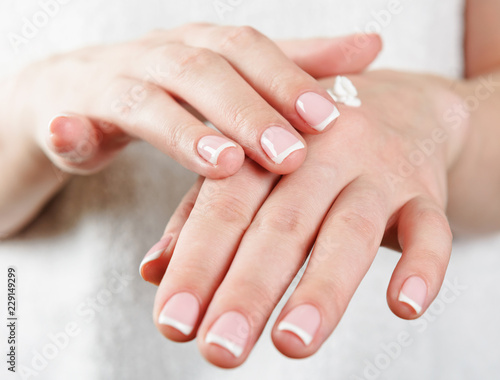 woman s hands applying cream
