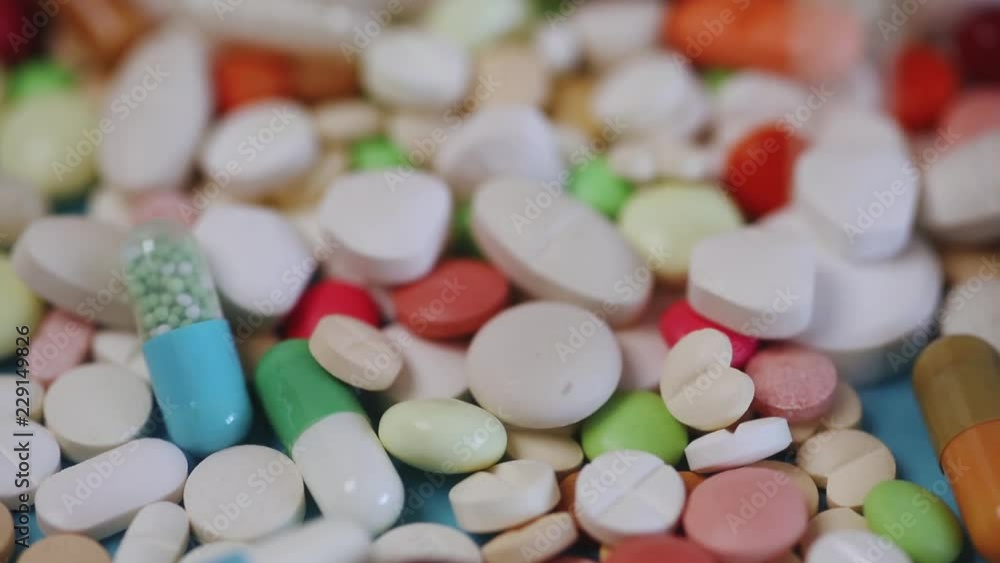 Closeup of colorful pills with new pills falling into view Closeup of colorful pills with new pills falling into view