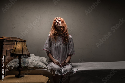 Scary woman possessed by devil in the bed. Exorcism of priest.