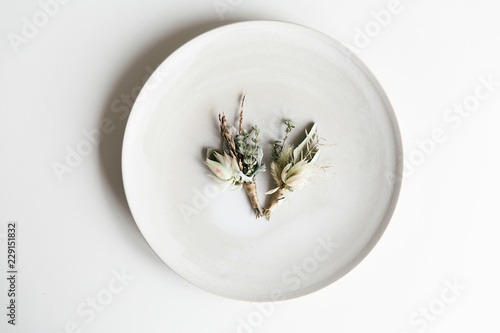 Two floral corsages lying on a plate.