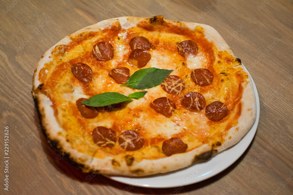 Delicious italian pizza. Tasty traditional italian pepperoni pizza on white plate.