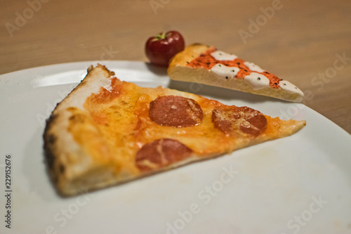 Delicious italian pizza. Tasty traditional italian pepperoni pizza on white plate. Slices of Italian pepperoni pizza