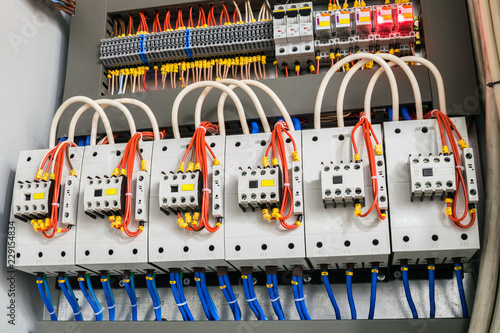 A modern open fuse box contains a lot of automata, connectors, relays, and magnet starters. Distributive electrical box. photo