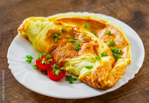 omelette in a white plate on wooden table photo
