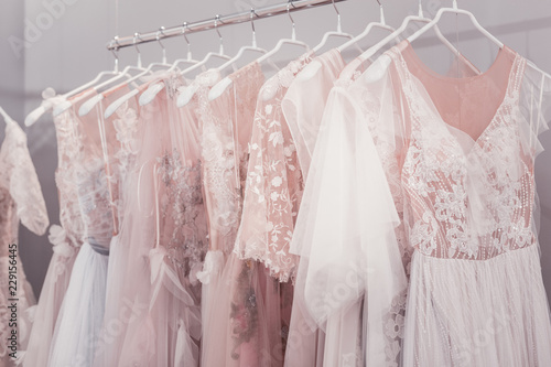 Wedding dress boutique. Beautiful wedding dresses hanging on hangers in the wedding shop © Viacheslav Yakobchuk