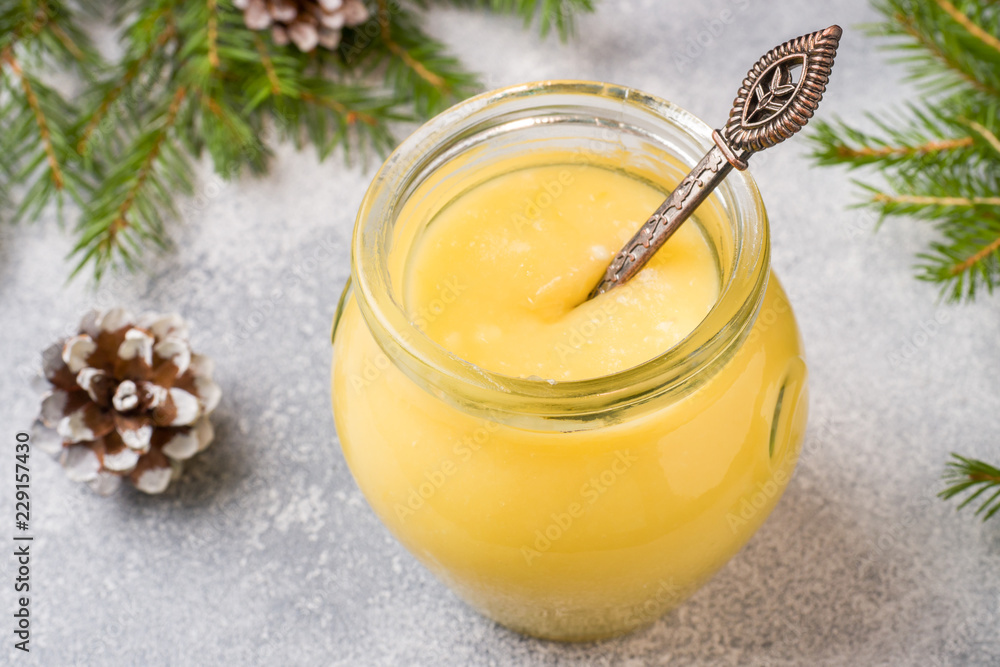 Homemade lemon curd in glass jars on the table. Concept Christmas Homemade lemon curd in glass jars on the table. Concept Christmas