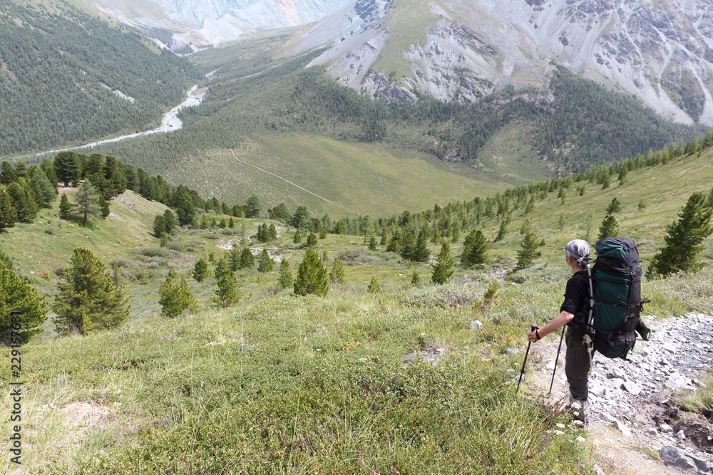 Man with a backpack standing on the pass Kara-Turek, view of the Jarlu River  valley