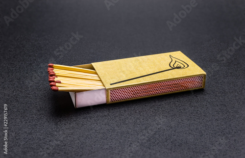 Long matches lying in a matchbox on a black background, with a clipping path.
