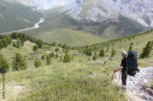 Man with a backpack standing on the pass Kara-Turek, view of the Jarlu River  valley © Nataliia Makarova